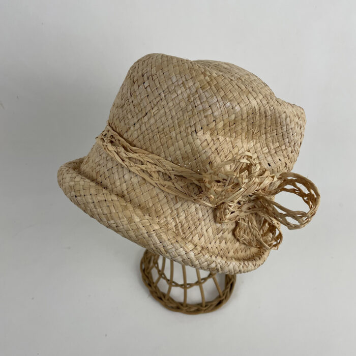 Chapeau cloche en rafia garni d'une tresse de rafia ajourée terminée par un noeud