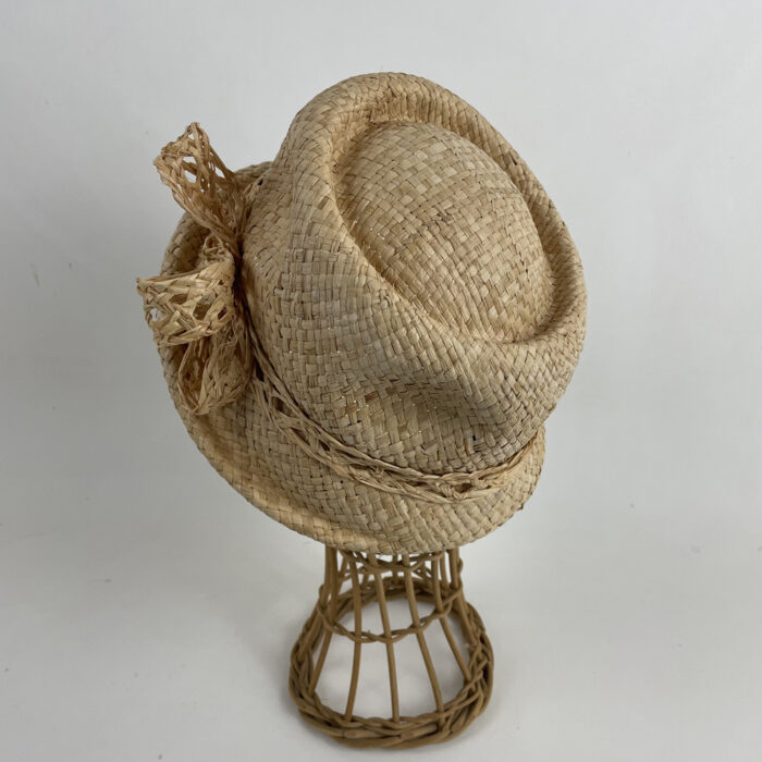 Chapeau cloche en rafia garni d'une tresse de rafia ajourée terminée par un noeud