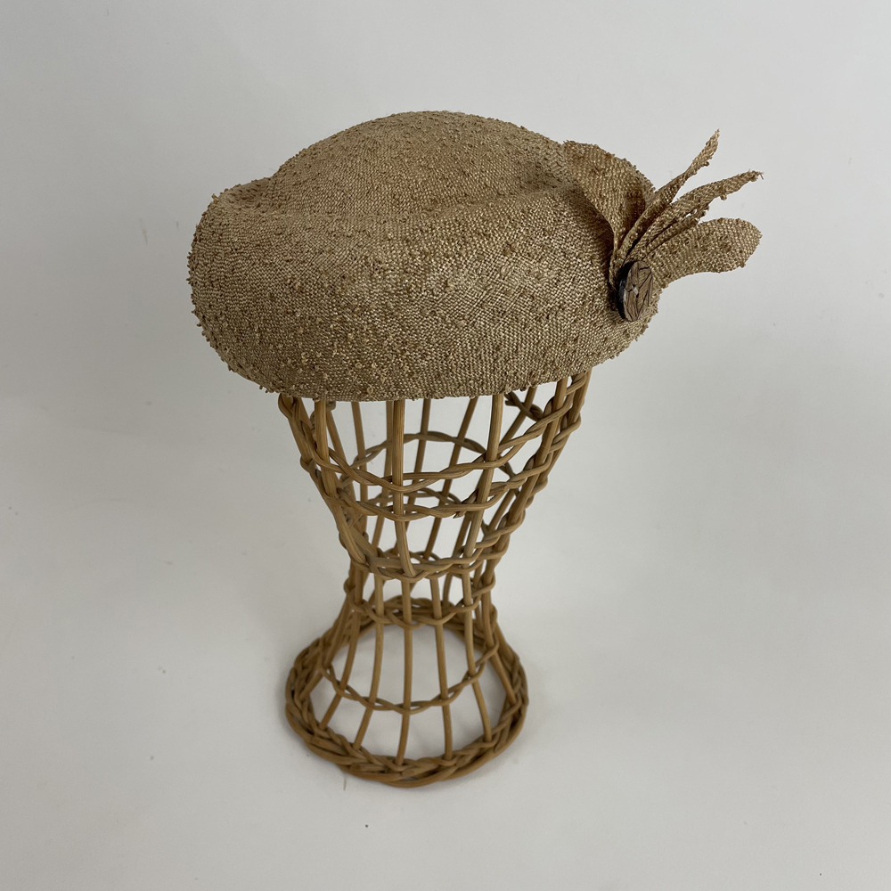 Toque en paille fine à picot mordoré garni de pétales coordonnées et d'un bouton en noix de coco