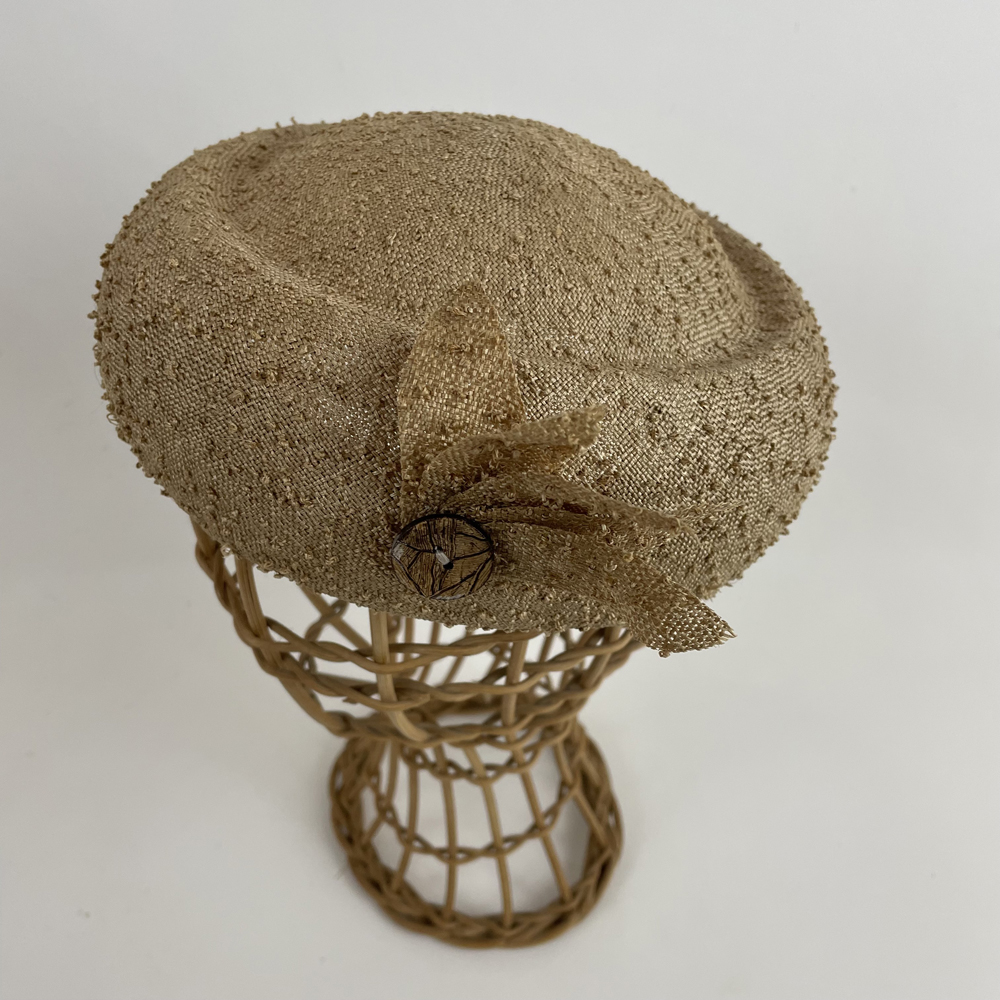 Toque en paille fine à picot mordoré garni de pétales coordonnées et d'un bouton en noix de coco